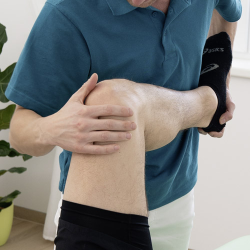Physiotherapeut behandelt das Kniegelenk.
