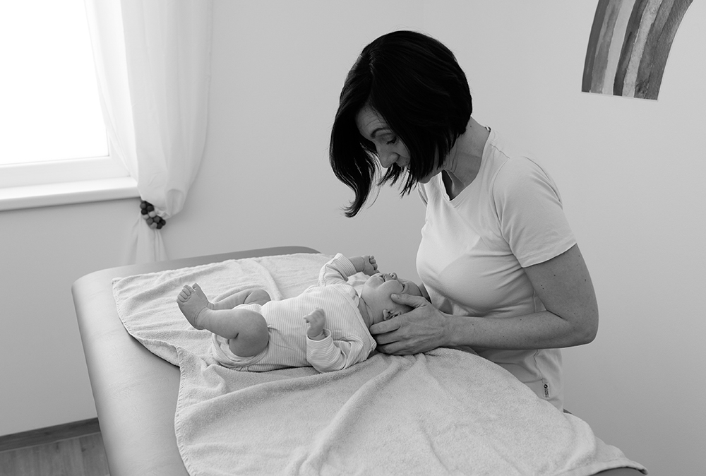Melanie Flautner behandelt ein Baby auf einer Therapieliege. Foto: schwarz-weiß.