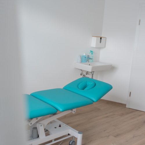 Türkis farbene Liege in einem Therapieraum