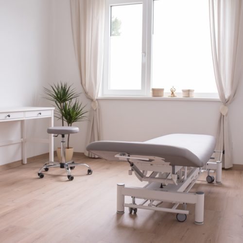 Therapieraum für Osteopathie mit einer grauen Behandlungsliege im Therapiezentrum Fixpunkt.